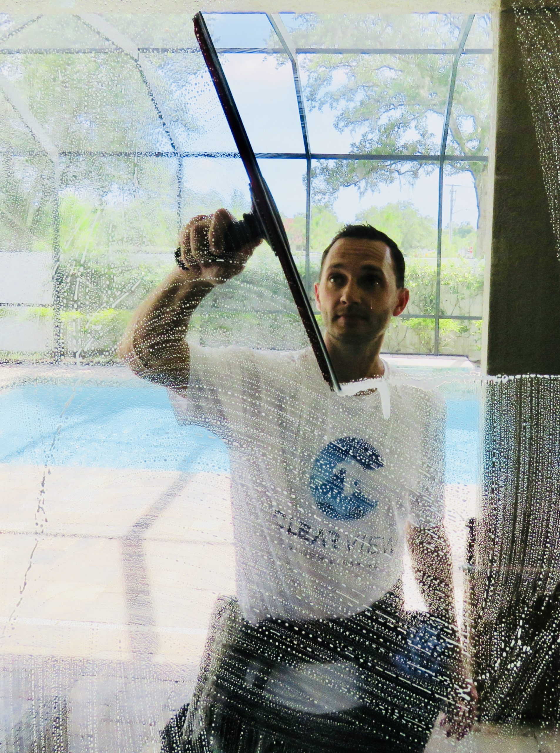 Clearview Window Cleaning technician squeegeeing a window in Sarasota